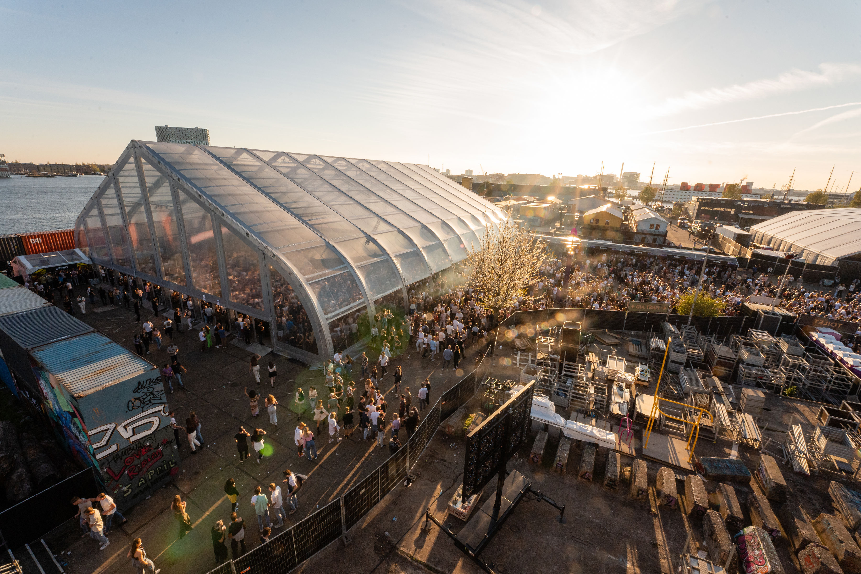 Overview of DGTL festival tents and visitor areas at sunset